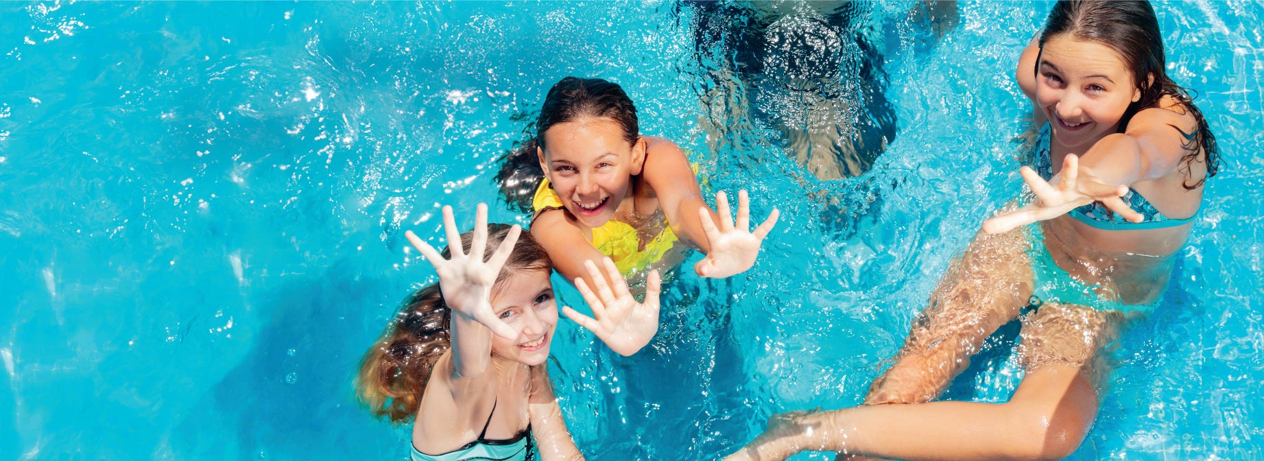 Drei fröhliche Kinder winken aus einem sonnigen Pool