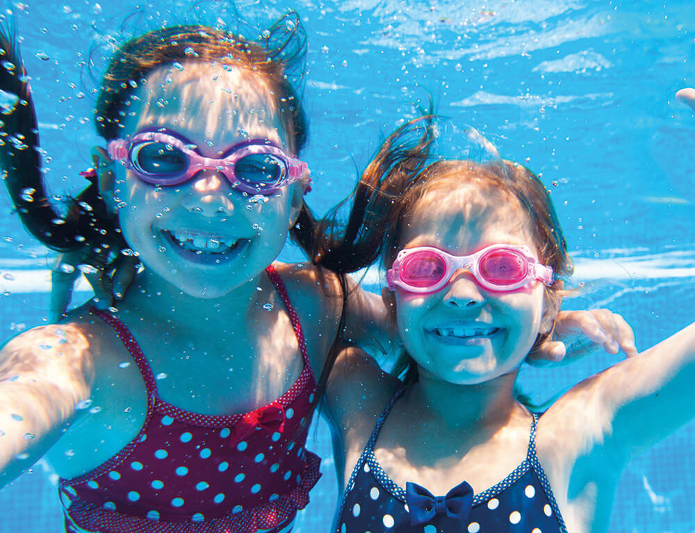 Zwei Kinder in einem Swimmingpool beim Tauchen
