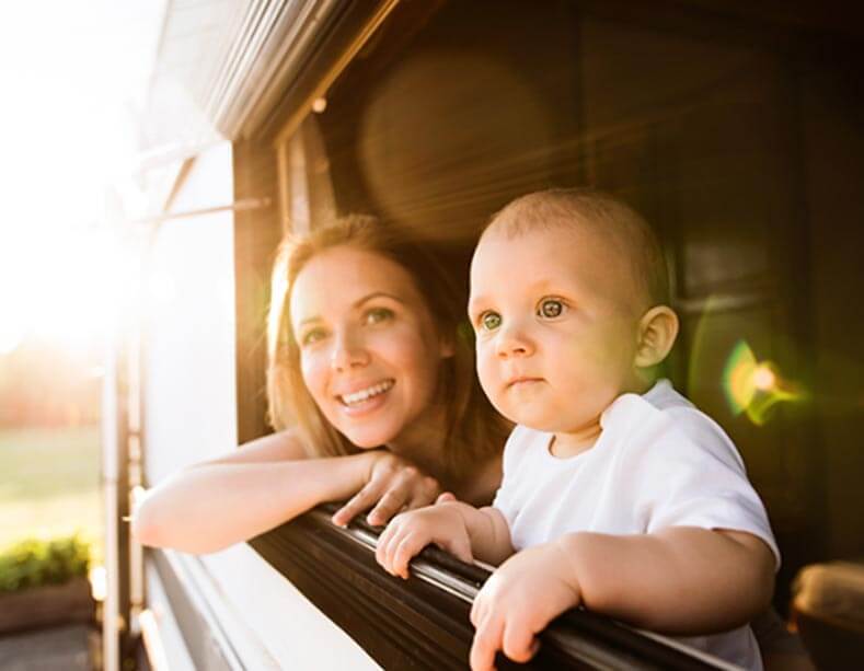 Mutter und Kind schauen aus dem Fenster eines Wohnmobils